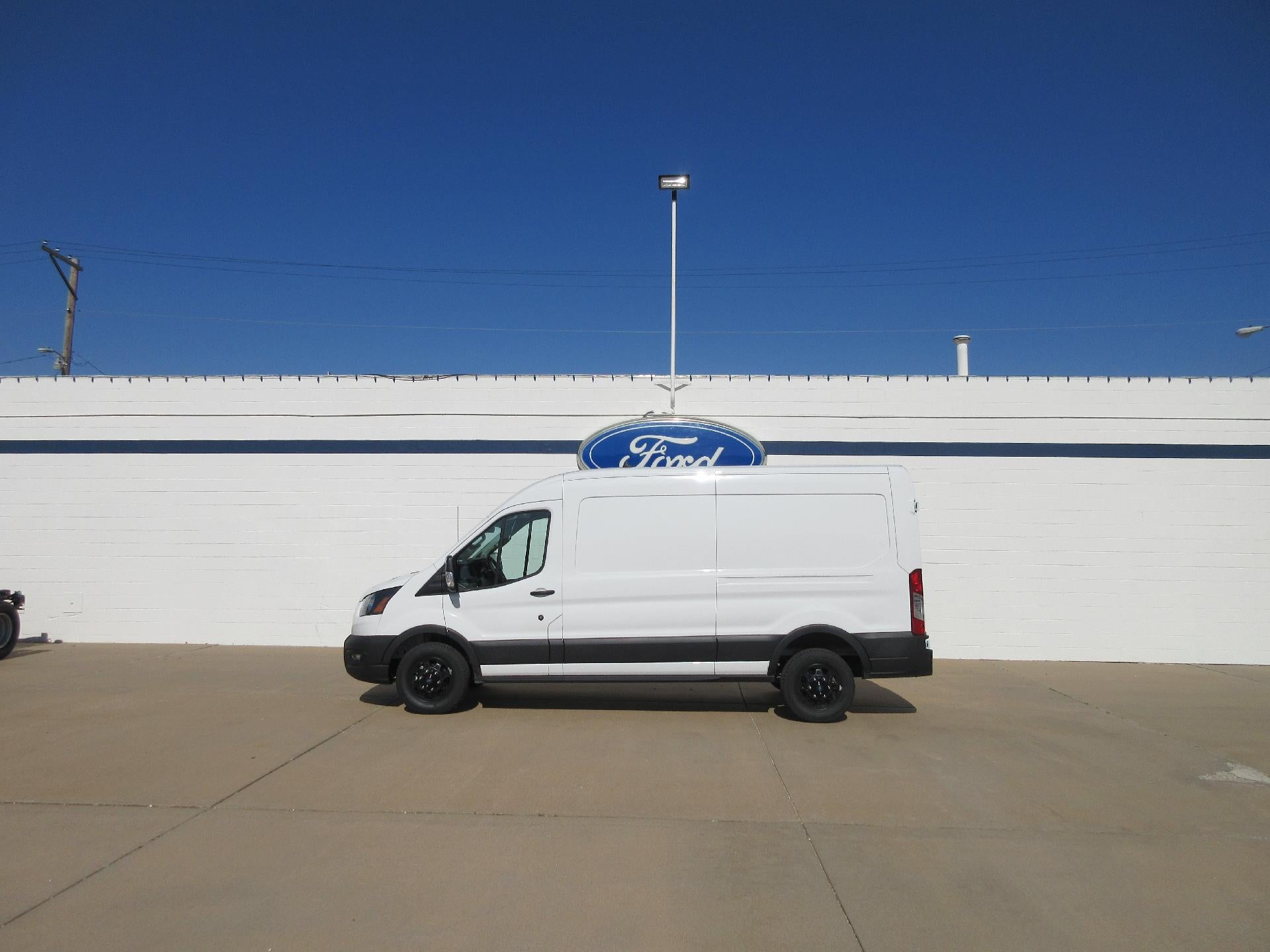 2025 Ford Transit Cargo Van T-150 148" Med Rf 8670 GVWR RWD in Oxford White — front three-quarter view